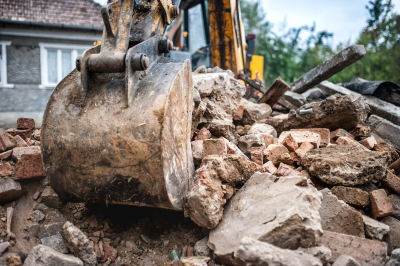 industrial hydraulic backhoe bulldozer loading demolition debris, stone and concrete for recycling